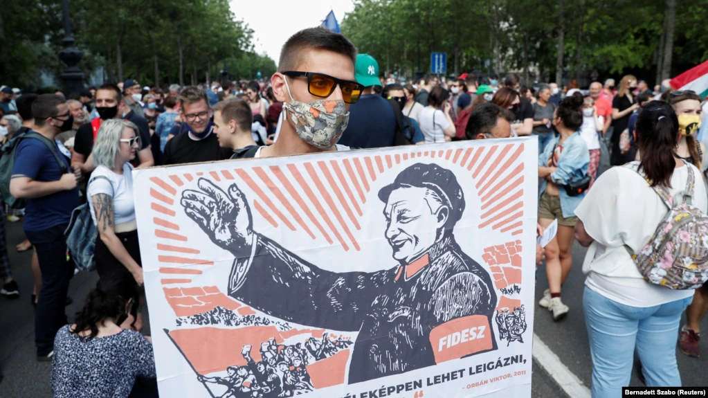 A demonstrator holds a placard depicting Hungarian Prime Minister Viktor Orban as Chinese communist leader Mao Zedong during a protest against the planned Chinese Fudan University campus in Budapest in June.