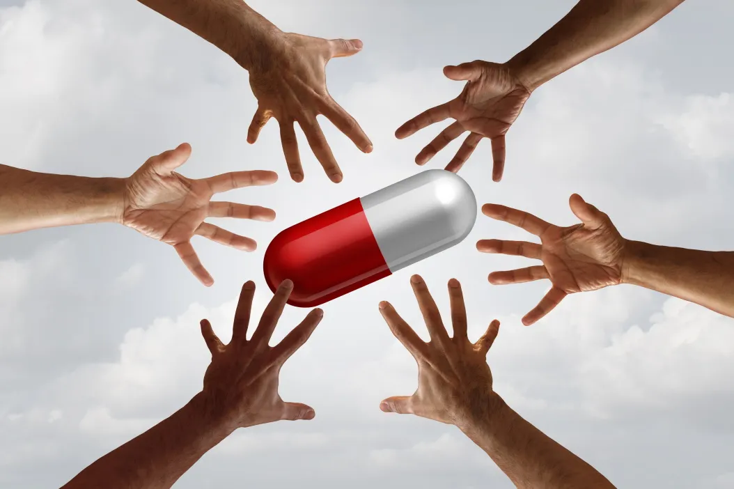 Image of hands reaching out towards giant pill