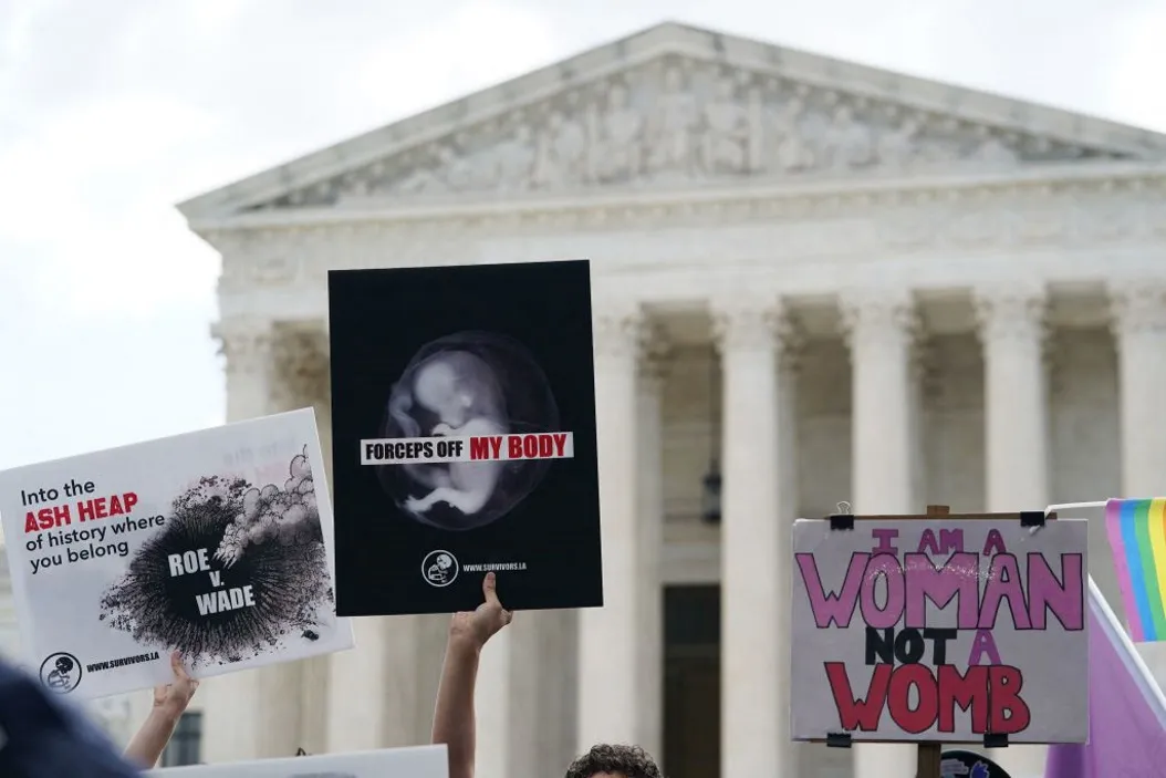 Pro-choice and pro-life signs are seen outside the US Supreme Court in Washington, DC, on June 24, 2022