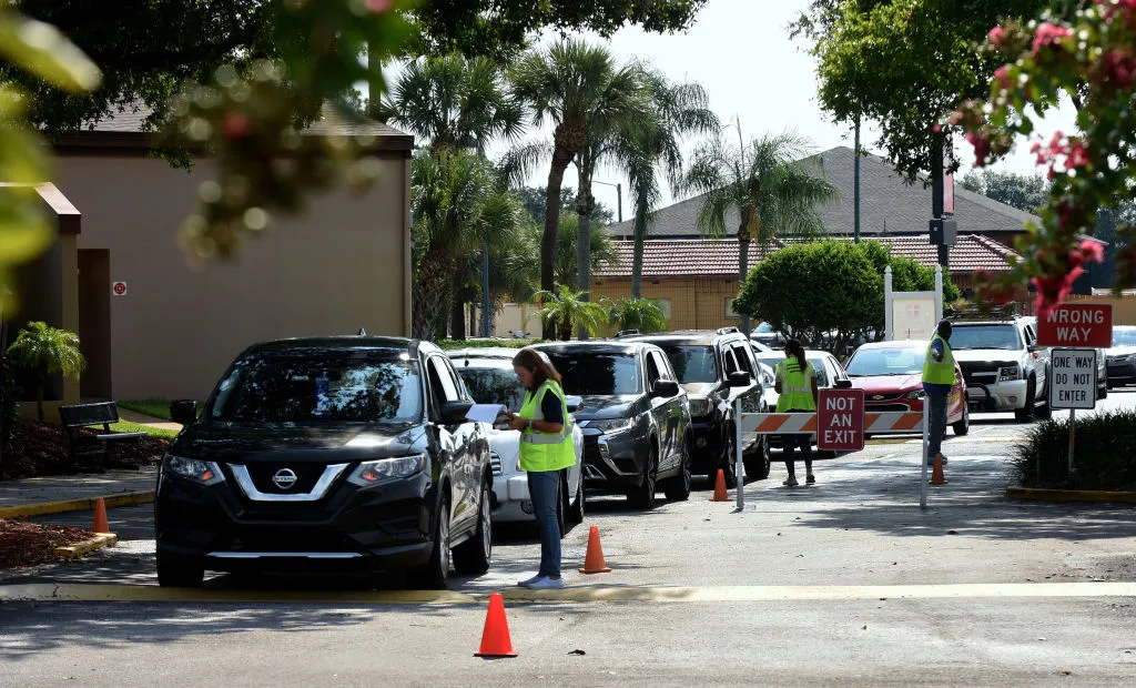 Cars line up to enter a food distribution event in Orlando, Florida.