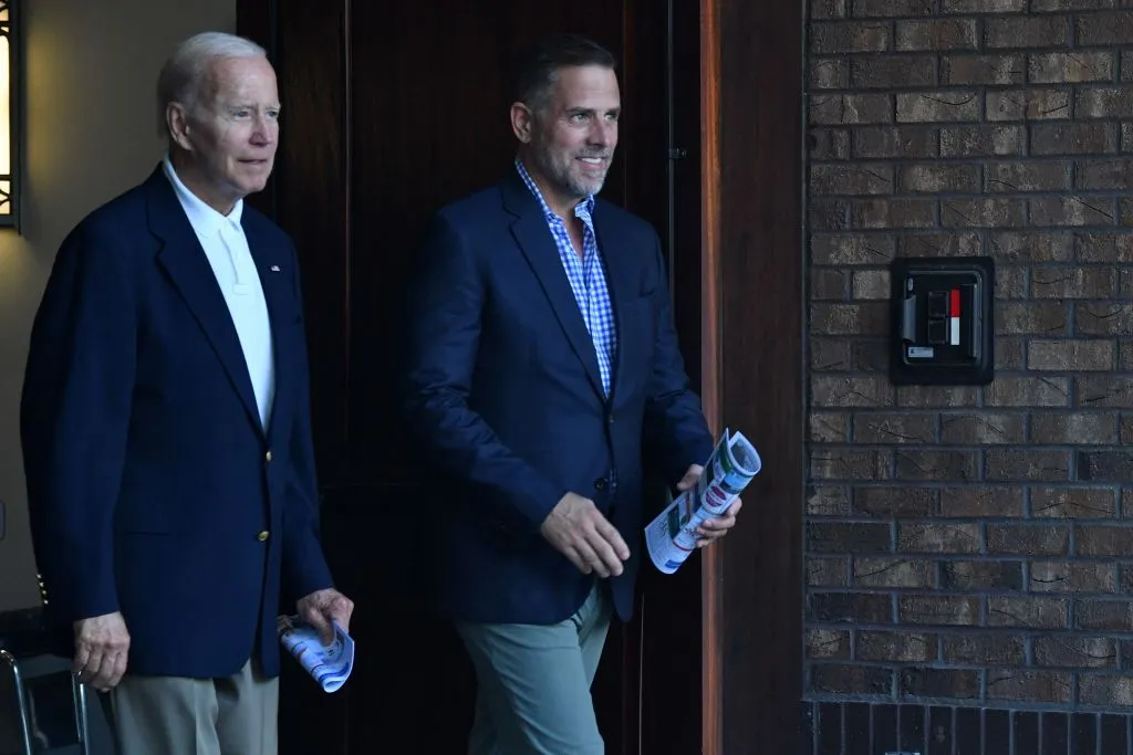 President Joe Biden (L) waves alongside his son Hunter Biden after attending mass at Holy Spirit Catholic Church