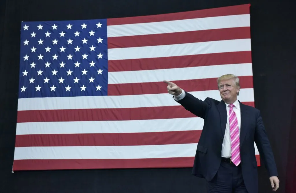 Donald Trump in front of the American Flag pointing